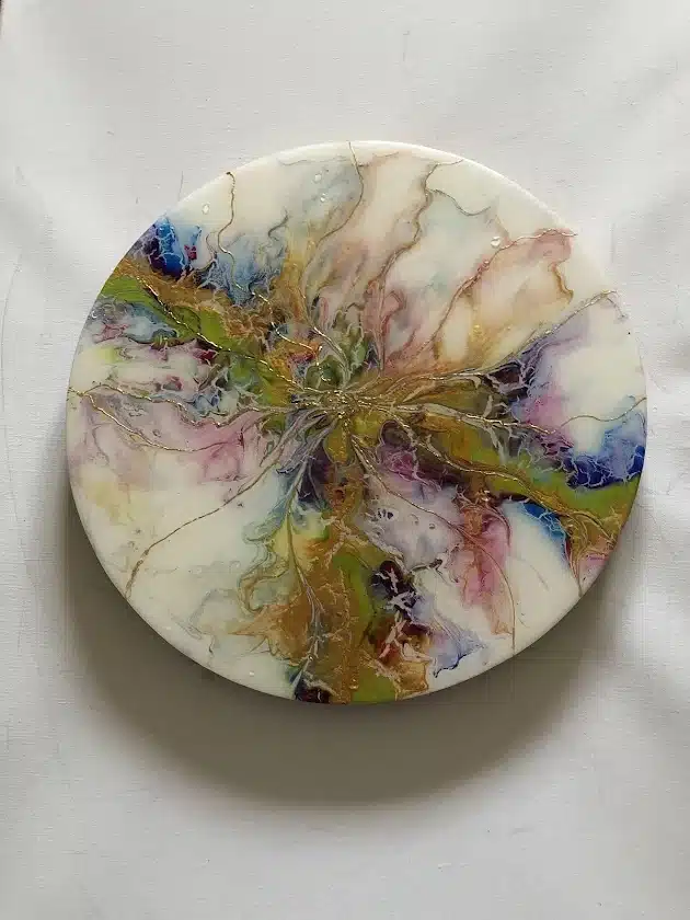 Art fluide circulaire aux couleurs éclatantes vert, bleu et violet rehaussé de fines nervures dorées sur fond blanc.