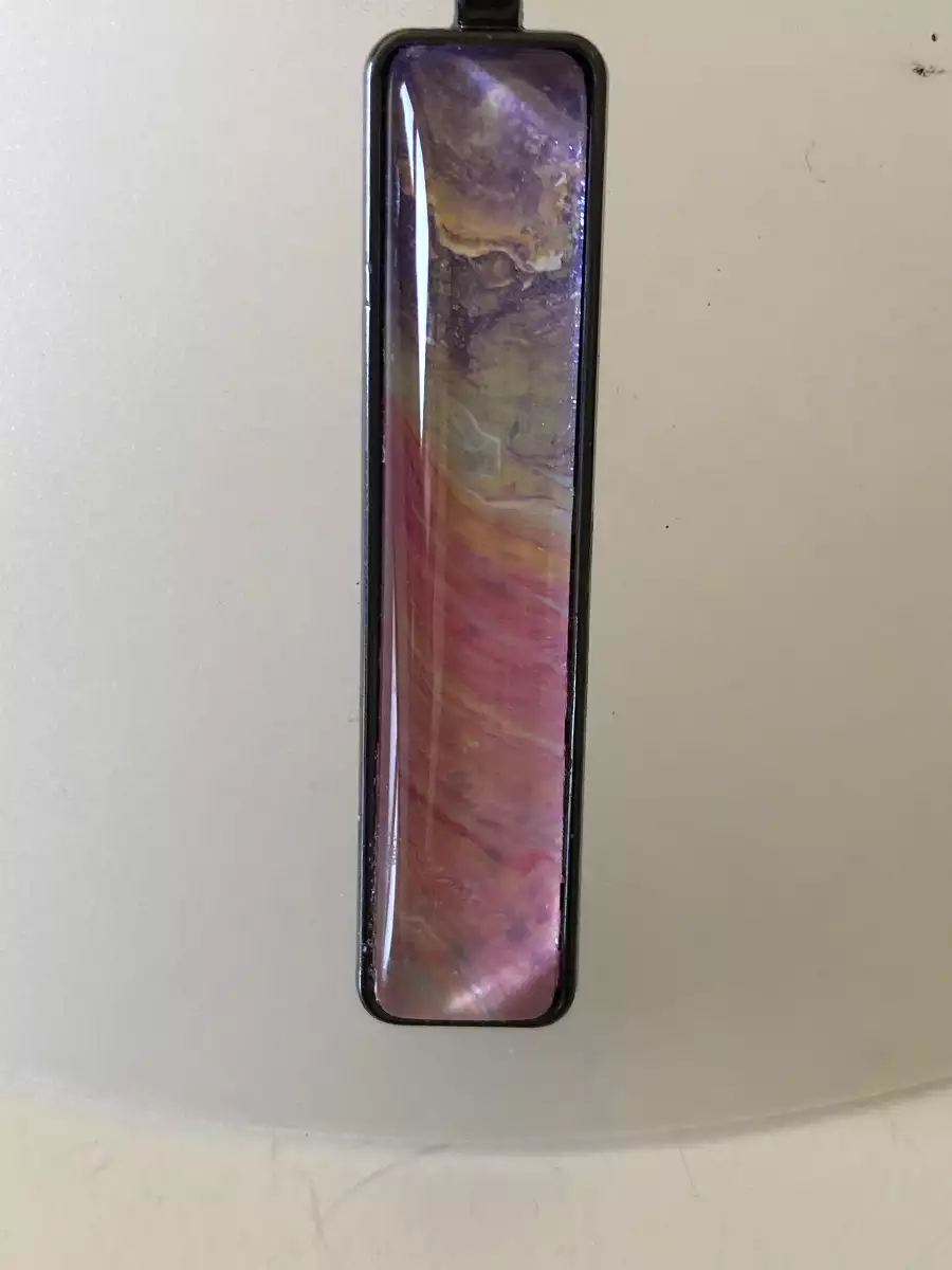 Pendentif rectangulaire noir avec motif abstrait d'art fluide aux tons violet, jaune et rose.