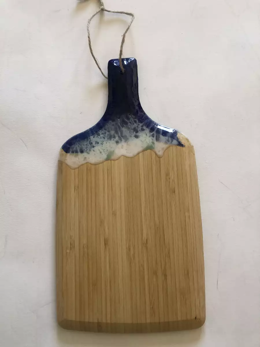 Planche à découper en bambou avec décor en résine époxy bleue et blanche, style vagues marines.